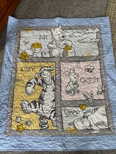 the winnie the pooh quilt is on the floor