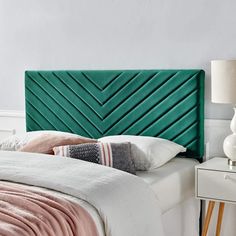 a green headboard on a white bed in a bedroom