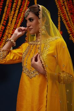 Cadmium yellow kurta with gota embroidery. Comes with gharara and a dupatta.
Components: 3
Pattern: Embroidered
Type Of Work: Gota
Neckline: Boat Neck
Sleeve Type: Three quarter
Fabric: Kurta : Dupion, Gharara : Dupion and Net, Dupatta : Net, Lining : Shantoon
Color: Yellow
Other Details: 
Closure : Side zip
Occasion: Mehendi and Haldi - Aza Fashions Gold Dola Silk Palazzo Set For Designer Wear, Designer Gold Dola Silk Palazzo Set, Gold Straight Kurta Palazzo Designer Set, Gold Designer Wear Palazzo Set With Straight Kurta, Gold Straight Kurta Palazzo Set For Designer Wear, Gold Palazzo Set With Straight Kurta For Designer Wear, Gold Palazzo Set With Dupatta For Eid, Gold Chinon Sharara For Eid, Bollywood Style Gold Palazzo Set For Eid