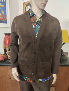 This is a rare find brown machine knit jacket with a suede leather front . It was made by Pierre Sangan of Jersey British Isles. The jacket is cardigan style, collarless with a V neck, four button closure with a spare inside the jacket should you loose one. It has two hip pockets. The condition is very good. The measurements are Chest 112cm Sleeves shoulder to cuff approx 65cm Length shoulder to hem 68cm Brown Single Breasted Sweater Coat With Long Sleeves, Brown Single Breasted Sweater Coat, Brown Single-breasted Long Sleeve Sweater Coat, Brown Single Breasted Cardigan For Work, Brown Single-breasted Cardigan For Work, Brown Workwear Cardigan With Pockets, Brown Buttoned Cardigan For Fall, Brown Cardigan With Pockets For Work, Casual Brown Leather Blazer