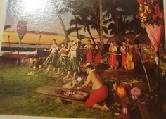 a group of people standing and sitting on top of a lush green field next to palm trees