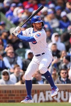 a baseball player holding a bat on top of a field in front of a crowd