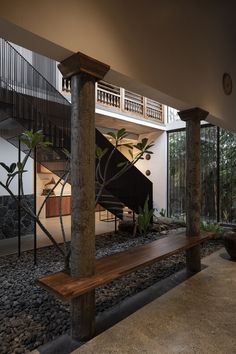 a wooden bench sitting in the middle of a room next to a stair case and stairs