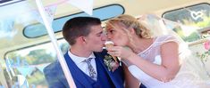 the bride and groom are kissing in front of their wedding party bus, as they eat cake