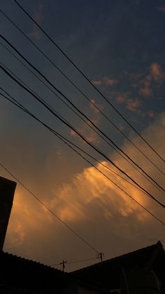 the sun is setting behind some power lines