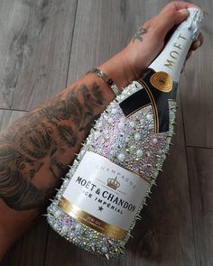 a person holding a bottle of champagne in their hand