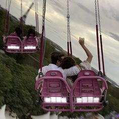 two people sitting on a pink swing ride