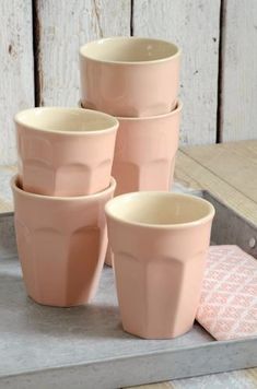 four pink cups sitting on top of a tray