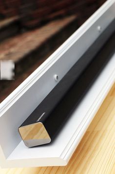 an electronic device mounted on the side of a window sill with wood in it