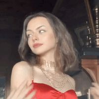 a woman in a red dress standing next to a clock