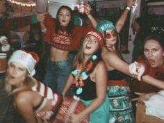 a group of young women standing next to each other in front of a christmas tree