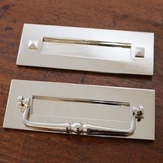 two chrome door handles on a wooden table