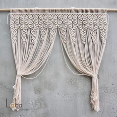 the curtains are hanging on the wall with tassels attached to them and tied together