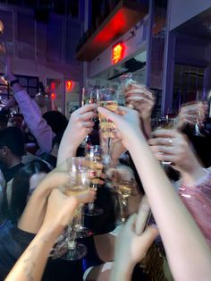 a group of people raising their glasses in the air