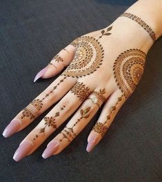 a woman's hand with henna tattoos on it