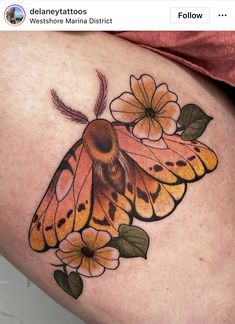 a close up of a butterfly on a woman's thigh with flowers around it