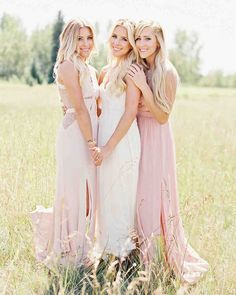 three beautiful women standing together in a field