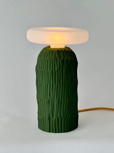 a green cactus lamp with a white light on it