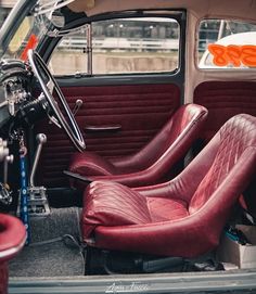 the interior of an old car with red leather seats and steering wheel hubs on it