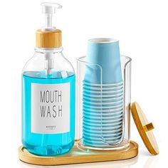 a soap dispenser, toothbrush holder and cups on a tray