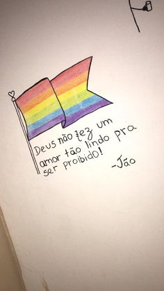 a rainbow colored pillow on top of a white wall next to a sign that says deus nao teg um lamor taco