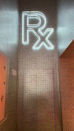 a public restroom with the word rx illuminated on the wall