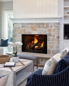 a living room filled with furniture and a fire place in the middle of the room