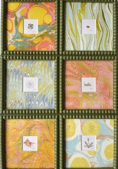 four different colored paintings in green frames