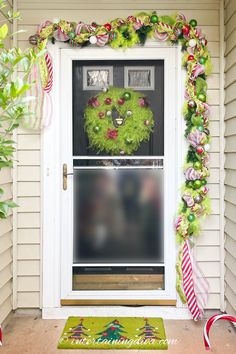 a christmas wreath on the front door of a house