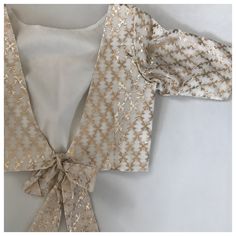 Foil weaving on chanderi makes this blouse a staple piece in your wardrobe. Pairing it with anything brings out the best results. Boat neck in front, bow tie at the back. Blouse comes with cups. Baby Clothes Vintage, Best Blouse Designs, Design Page