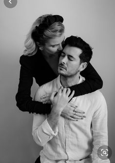 black and white photograph of a man hugging a woman's neck with both hands