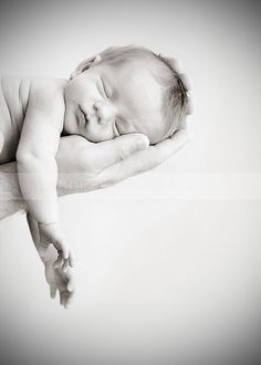 a black and white photo of a sleeping baby