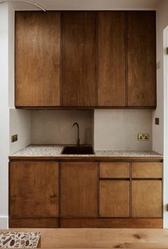 a kitchen with wooden cabinets and white walls