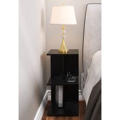 a night stand with a lamp on top of it in the corner of a room