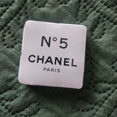 a white and black label that says no 5 chanel paris on the back of a green sweater