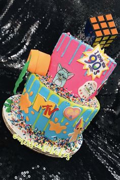 there is a multi layer cake decorated with colorful icing and sprinkles