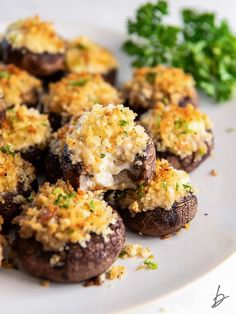 a white plate topped with stuffed mushrooms covered in cheese