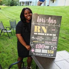 a woman standing next to a table with a sign on it