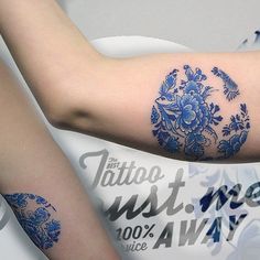 two people with tattoos on their arms and armbands, one has a blue flower tattoo