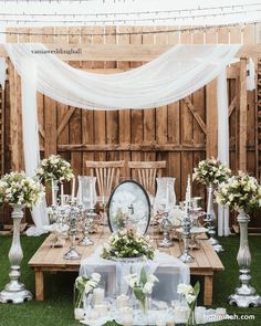 a wooden table topped with lots of white flowers