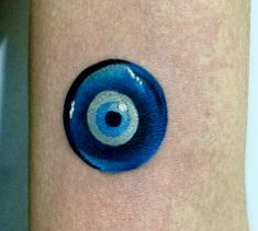 an eyeball tattoo on the arm of a person's arm with blue ink