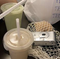 there is a cell phone and a cup on the table with straws in it