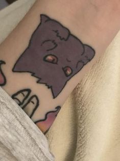 a person with a tattoo on their arm that has an image of a cat in it