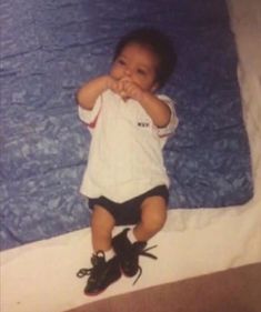 a young child sitting on top of a bed