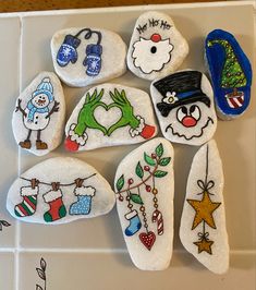 several decorated rocks sitting on top of a white tile counter next to a blue oven mitt