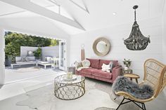 a living room filled with furniture and a chandelier hanging over the top of it