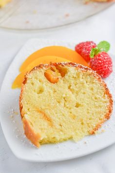 there is a piece of cake on the plate next to strawberries and oranges