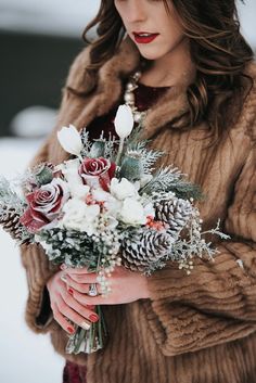 a woman wearing a fur coat holding a bouquet of flowers