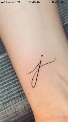 a small tattoo on the wrist of a woman's left arm, with an arrow in