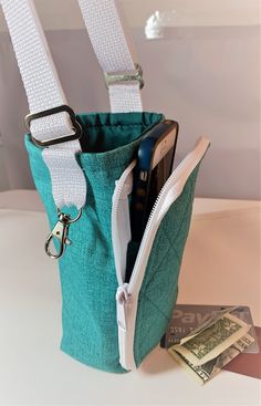 a cell phone in a green bag with white straps